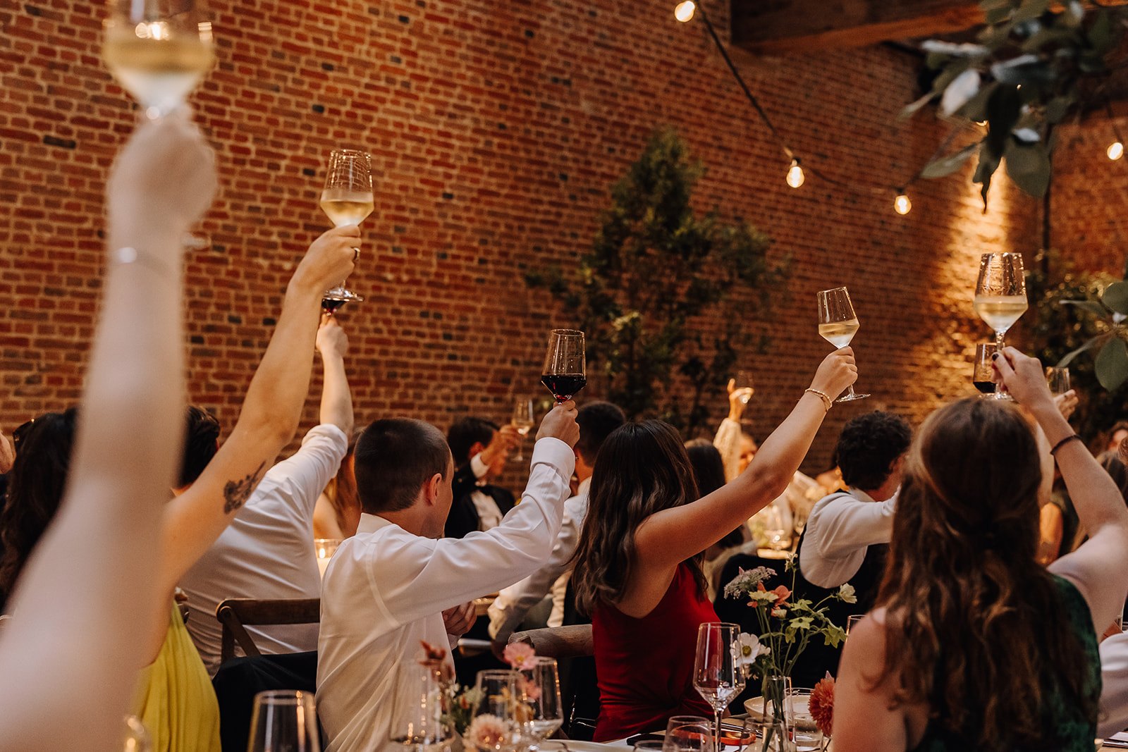 Gasten heffen het glas tijdens een toast op het verjaardagsfeest van Ilse