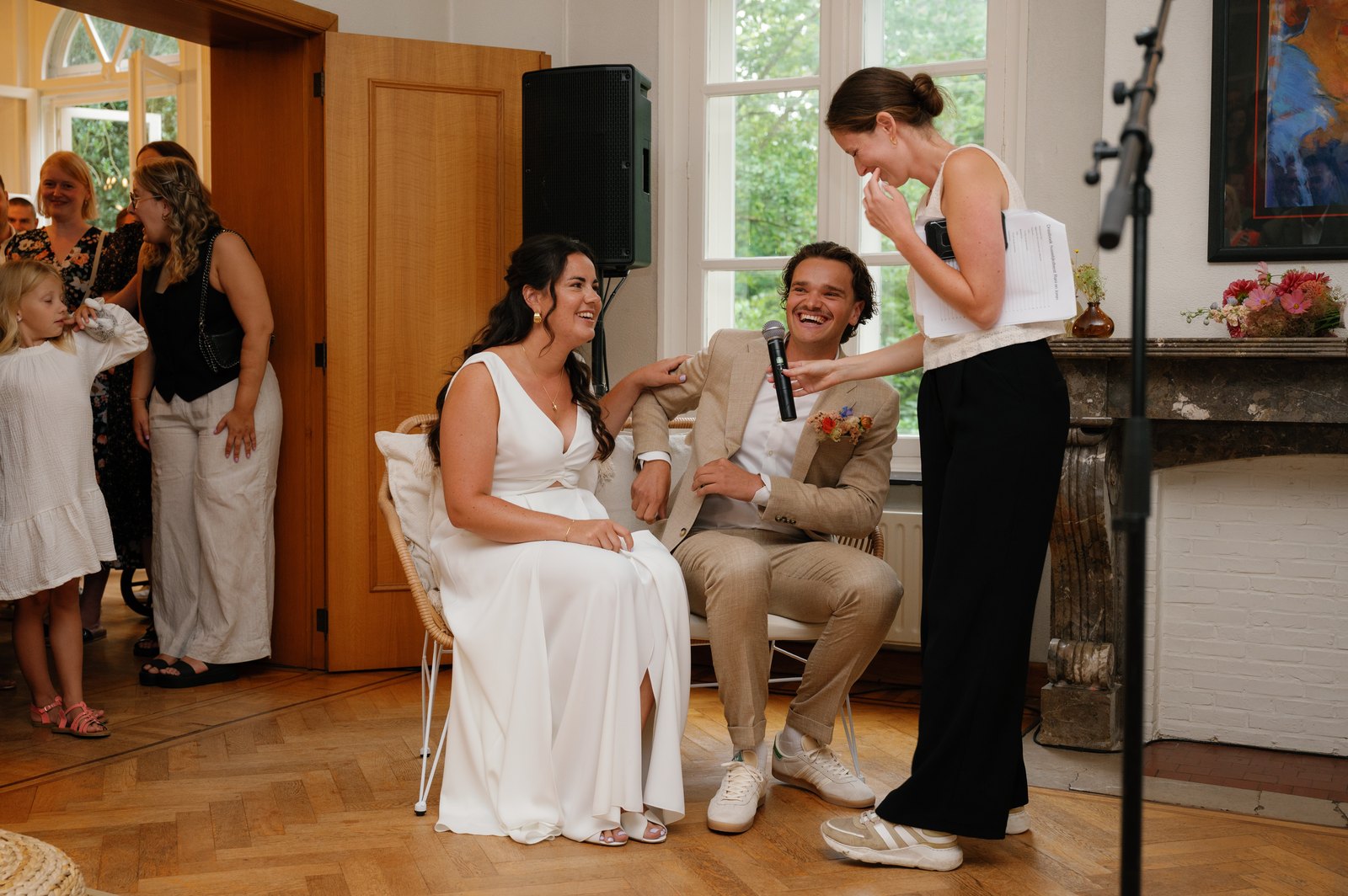 Jolien aan het werk tijdens een ceremonie, met draaiboek en micro naast het bruidspaar