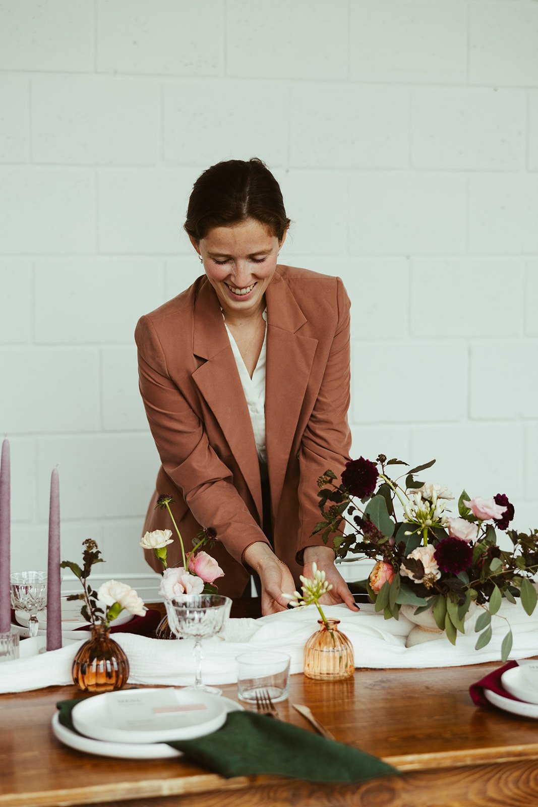 Jolien dekt een feesttafel met bloemen, kaarsen en linnen servetten