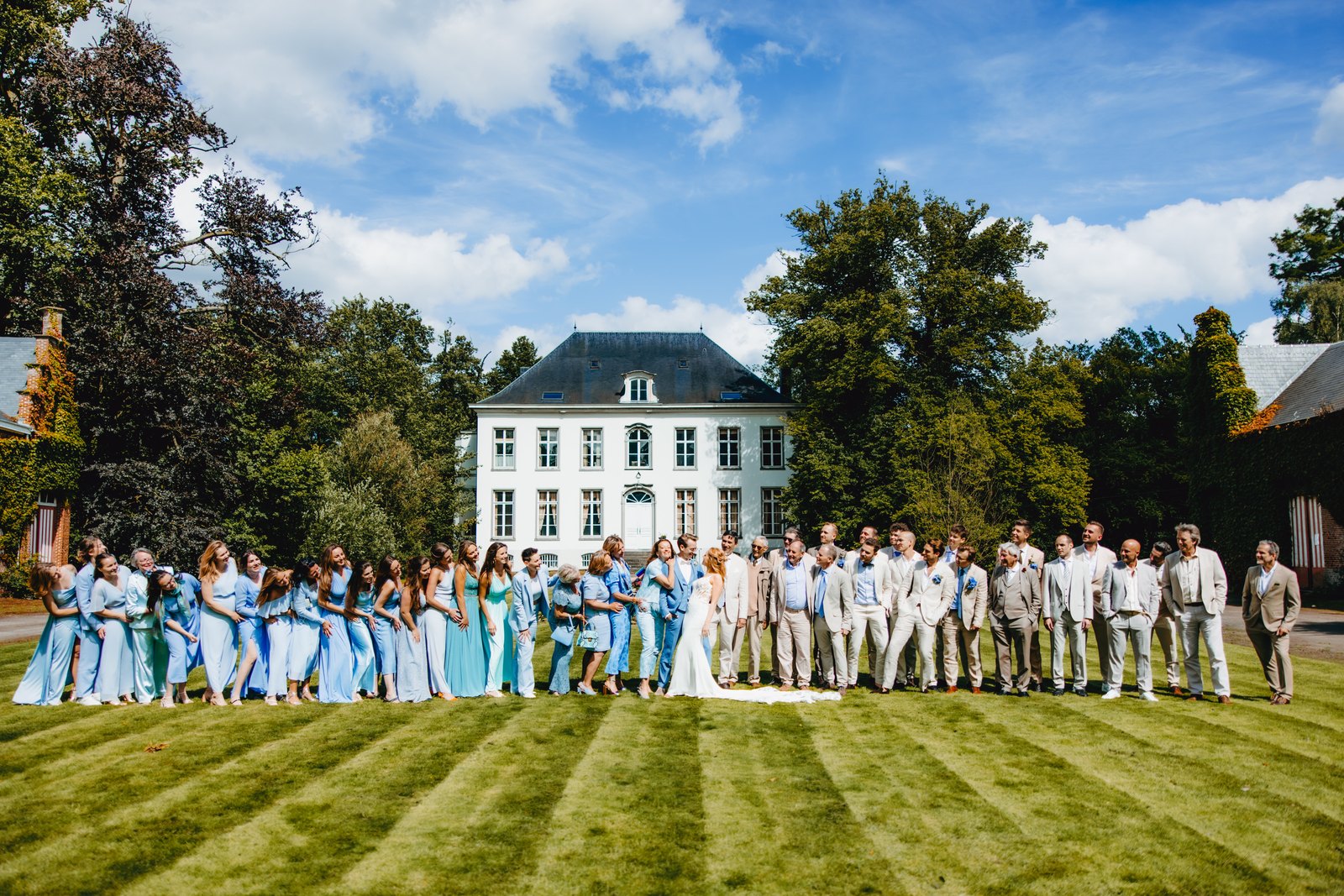 Groepsfoto van alle gasten voor het kasteel, trouwfeest van Joyce en Axel