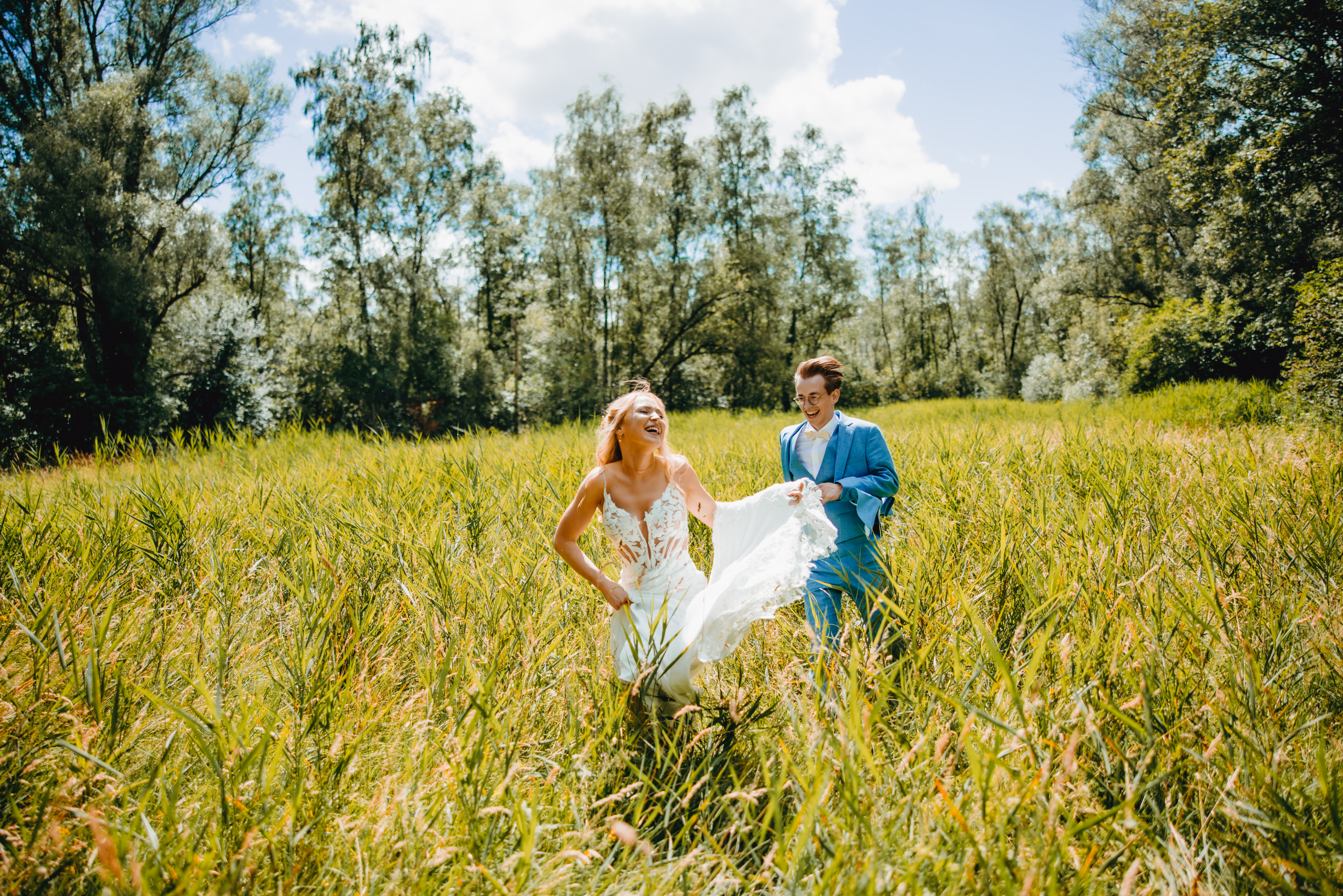 Een foto van de fotoshoot met het koppel Axel en Joyce. Ze lopen achter elkaar in een weide.